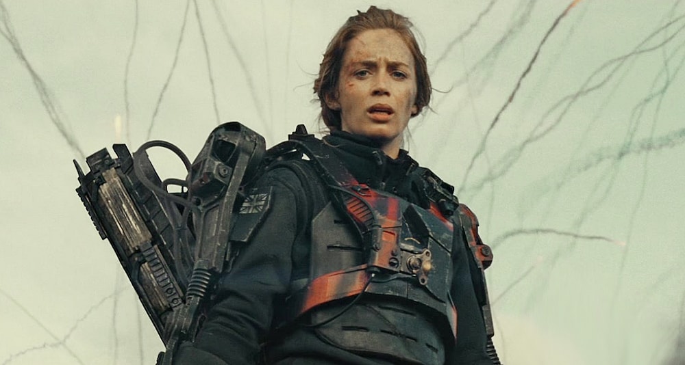 The Angel of Verdun (Emily Blunt) looks on as Major William Cage (Tom Cruise) embarrasses himself on the battlefield in Edge of Tomorrow (2014), Warner Bros. Pictures via Blu-ray