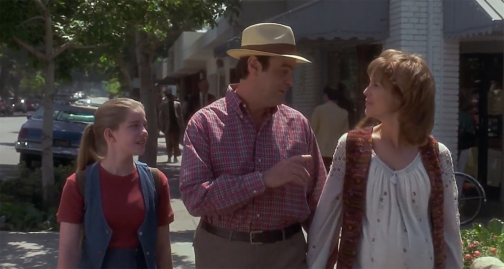 A man and woman walk with a girl.