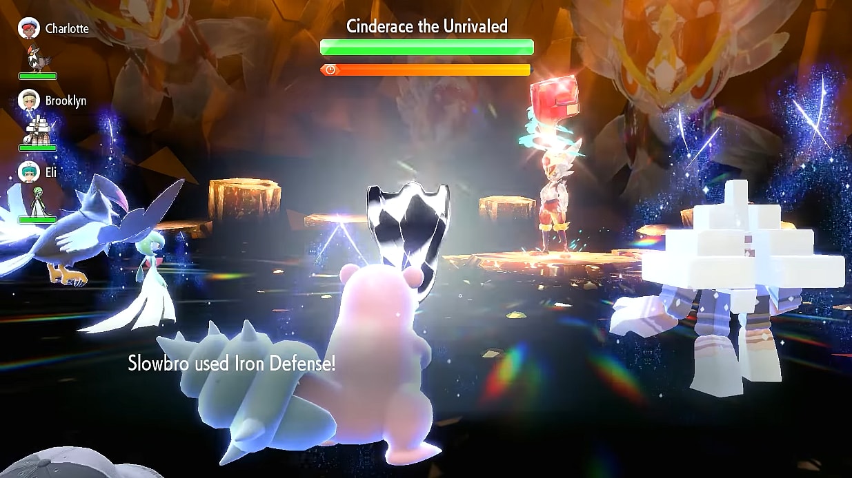 A Slowbro uses Iron Defense in a Tera Raid Battle against a Tera-Fighting Cinderace. A Gardevoir, Staraptor, and Garganacl are also battling via Pokémon Scarlet & Violet (2022), Nintendo