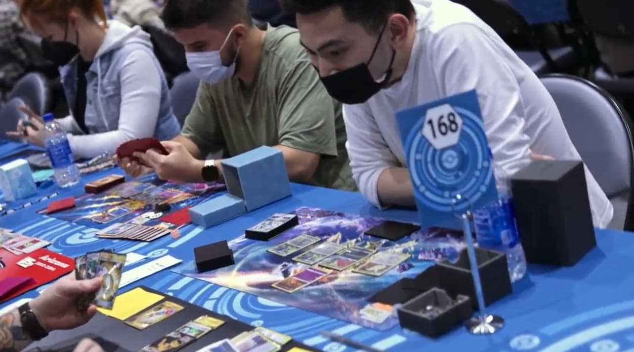 Multiple tables with players playing the Pokémon Trading Card Game wearing face masks via TCG Day 1 | 2023 Pokémon Charlotte Regional Championships, PokemonTCG Twitch