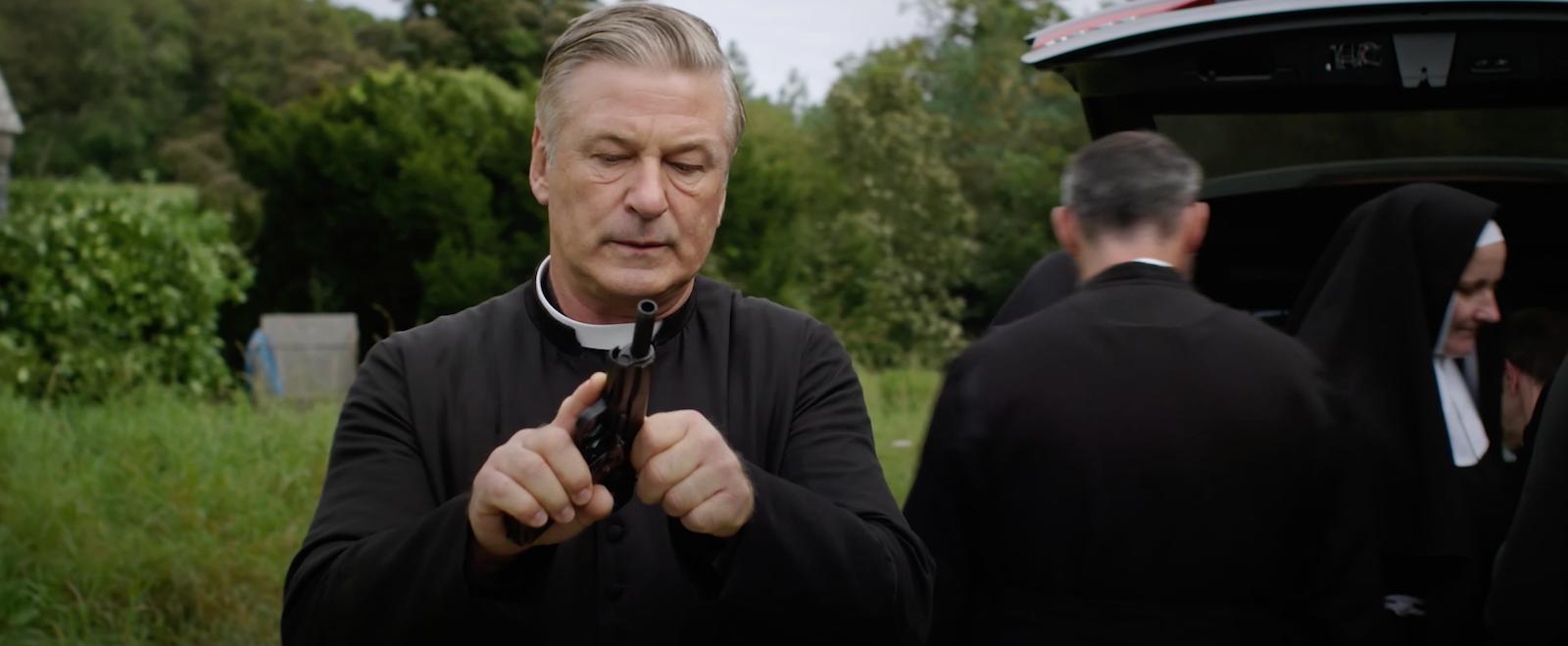 Father Hector McGrath (Alec Baldwin) checks the chamber in Pixie (2021), Paramount Pictures