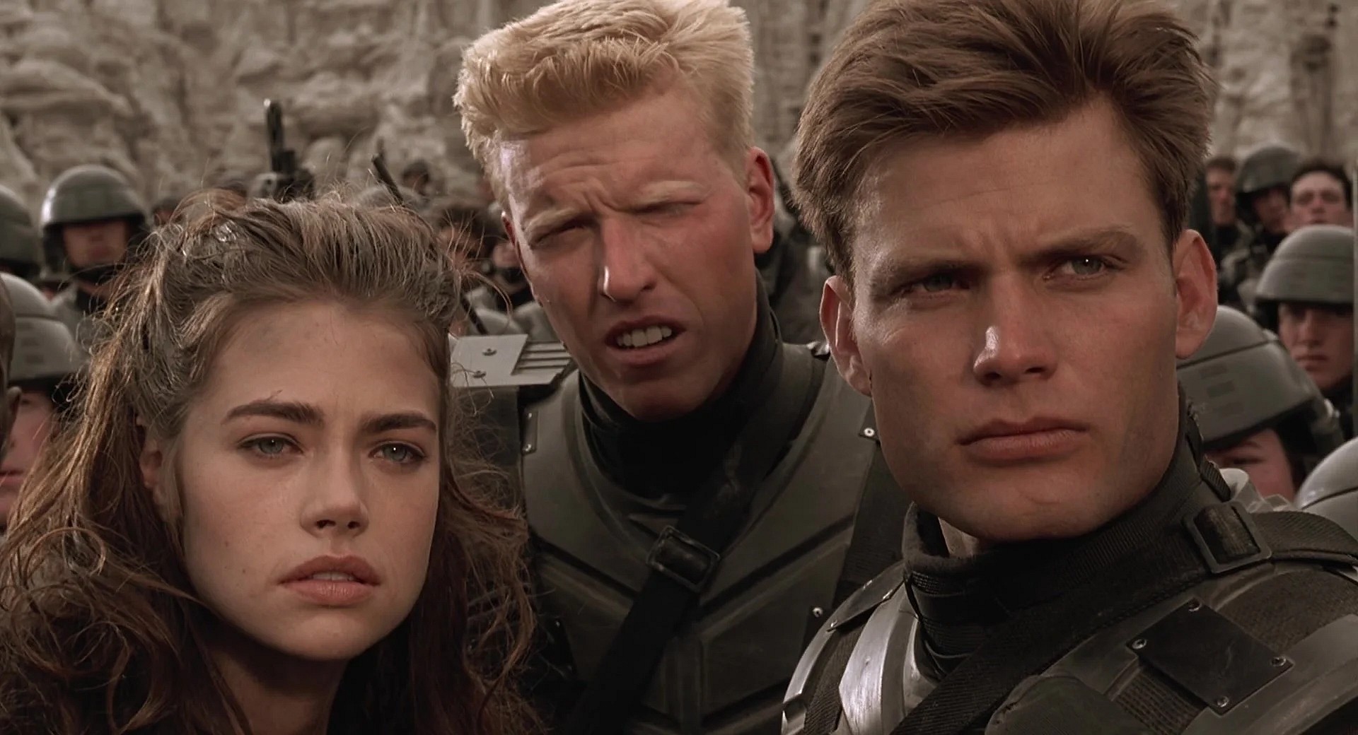 Carmen (Denise Richards), Ace (Jake Busey), and Johnny (Casper Van Dien) emerge from a Bug den in Starship Troopers (1997), Tri-Star Pictures