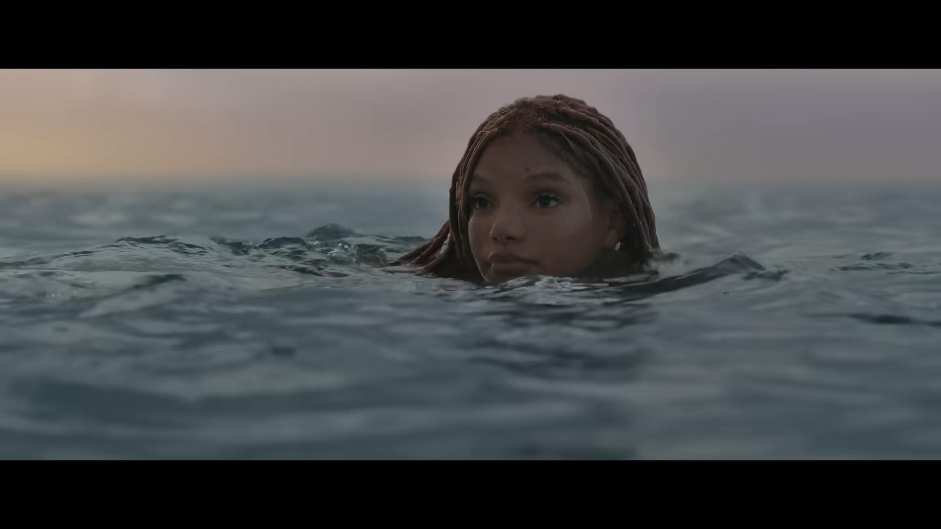 Ariel (Halle Bailey) pops her head above the ocean's surface in The Little Mermaid (2023), Disney