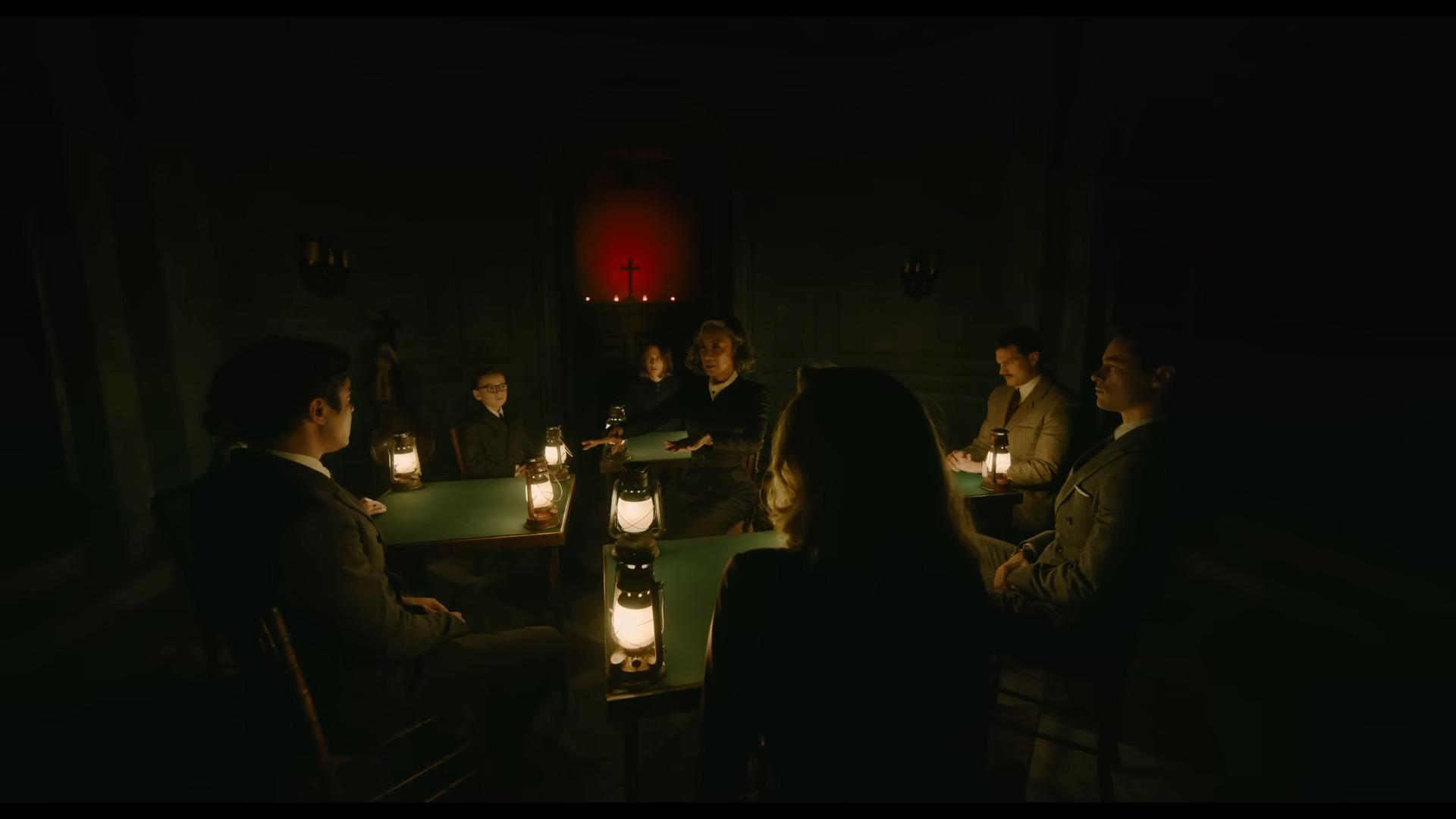 The cast awaits the results of their other-worldly communication in A Haunting in Venice (2023), 20th Century Studios
