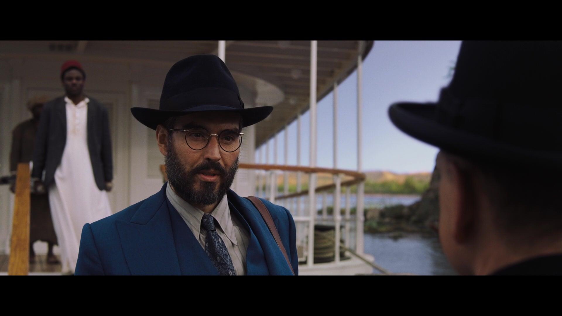 Dr. Windlesham (Russell Brand) thanks Inspector Poirot (Kenneth Branagh) for his help in solving the titular murder in Death on the Nile (2022), 20th Century Studios
