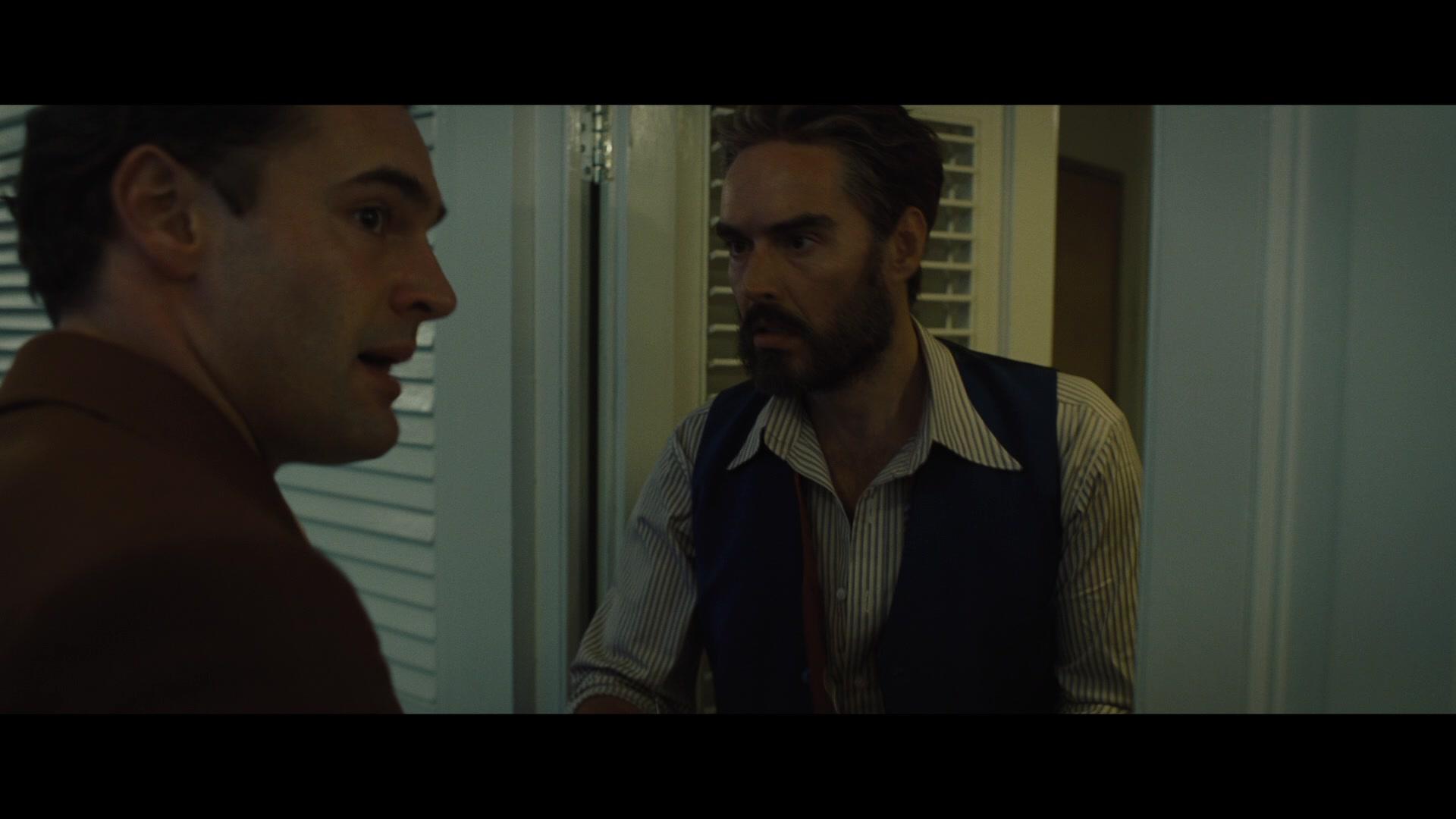 Dr. Windlesham (Russell Brand) is suddenly awoken by Bouc (Tom Bateman) in Death on the Nile (2022), 20th Century Studios