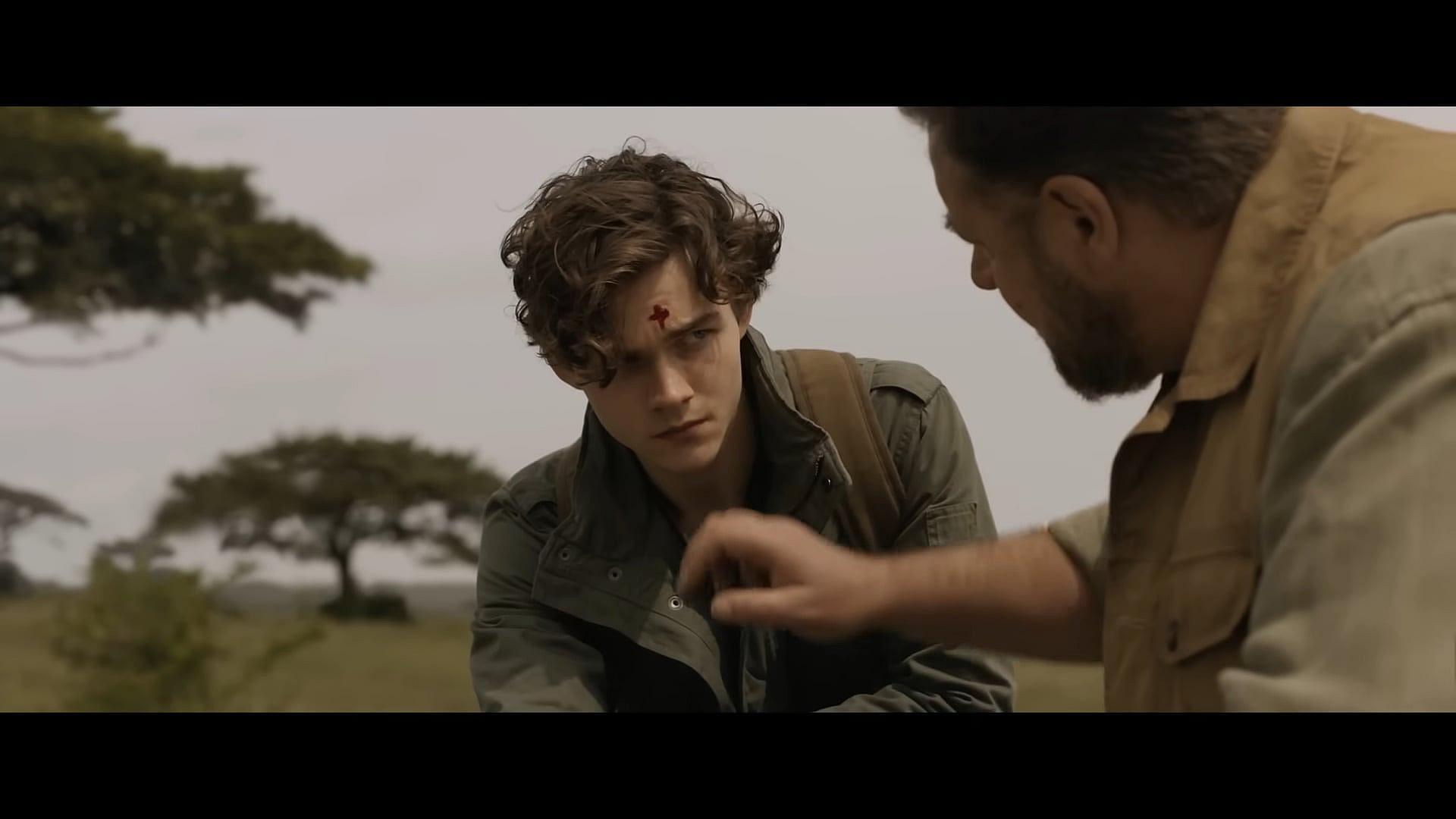Young Kraven (Levi Miller) taught lesson by father (Russell Crowe) in Kraven the Hunter (2023), Sony
