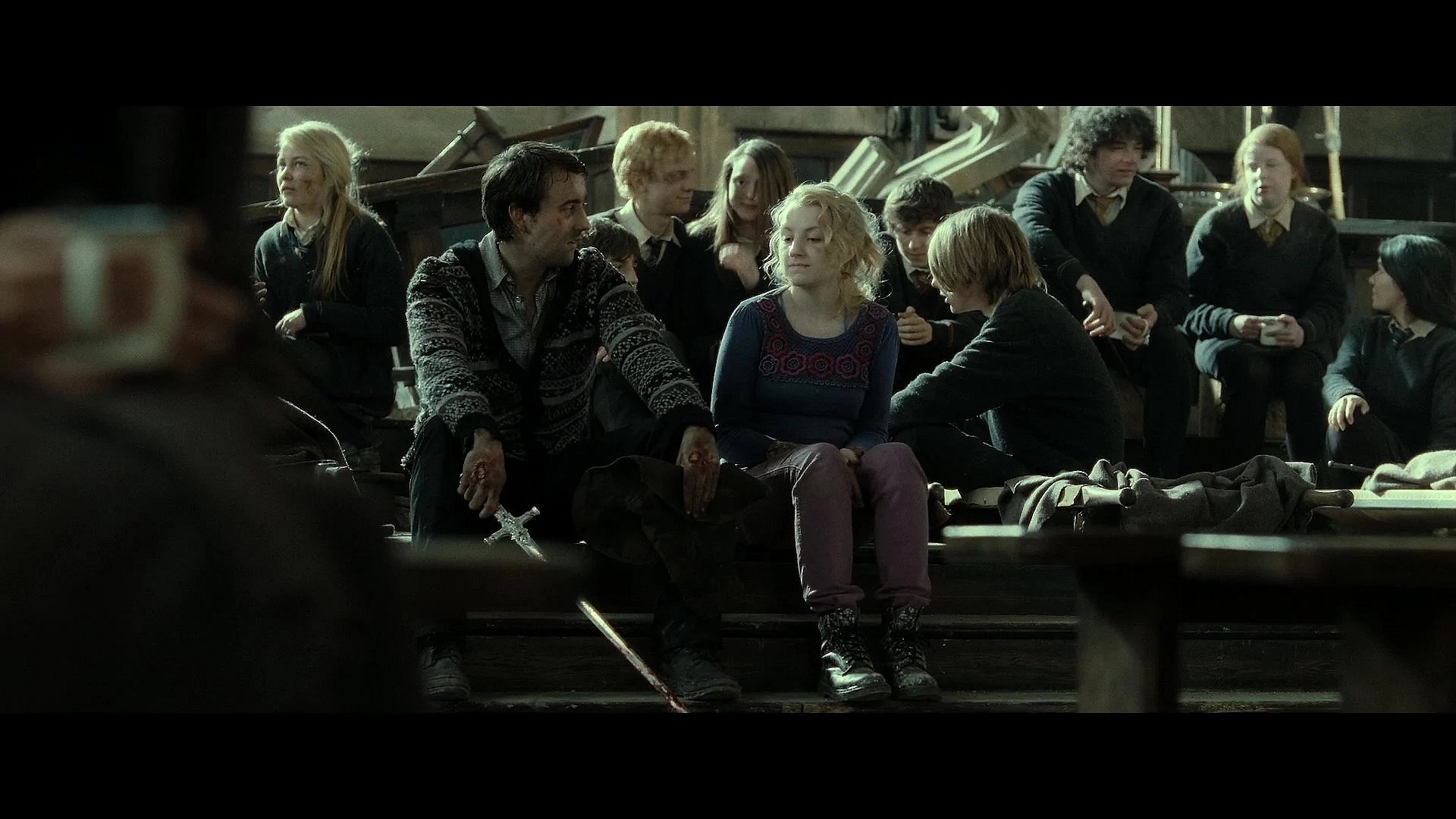 Neville Longbottom (Matthew Lewis) and Luna Lovegood (Evanna Lynch) take a breather following the Battle of Hogwarts in Harry Potter and the Deathly Hallows - Part 2 (2011), Warner Bros. Pictures