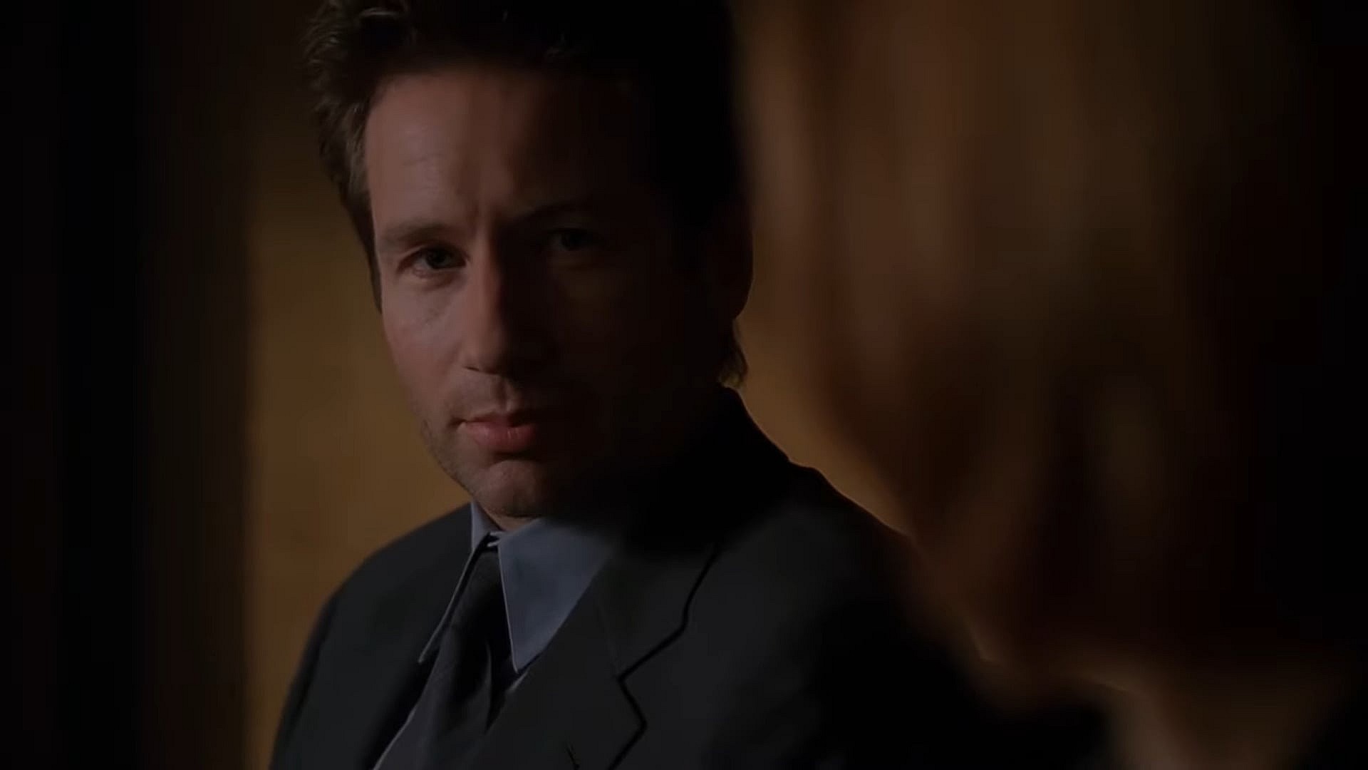 Agent Mulder (David Duchovny) realizes the team is trapped in a dream in The X-Files Season 6 Episode 21"Field Trip" (1999), 20th Century Studios