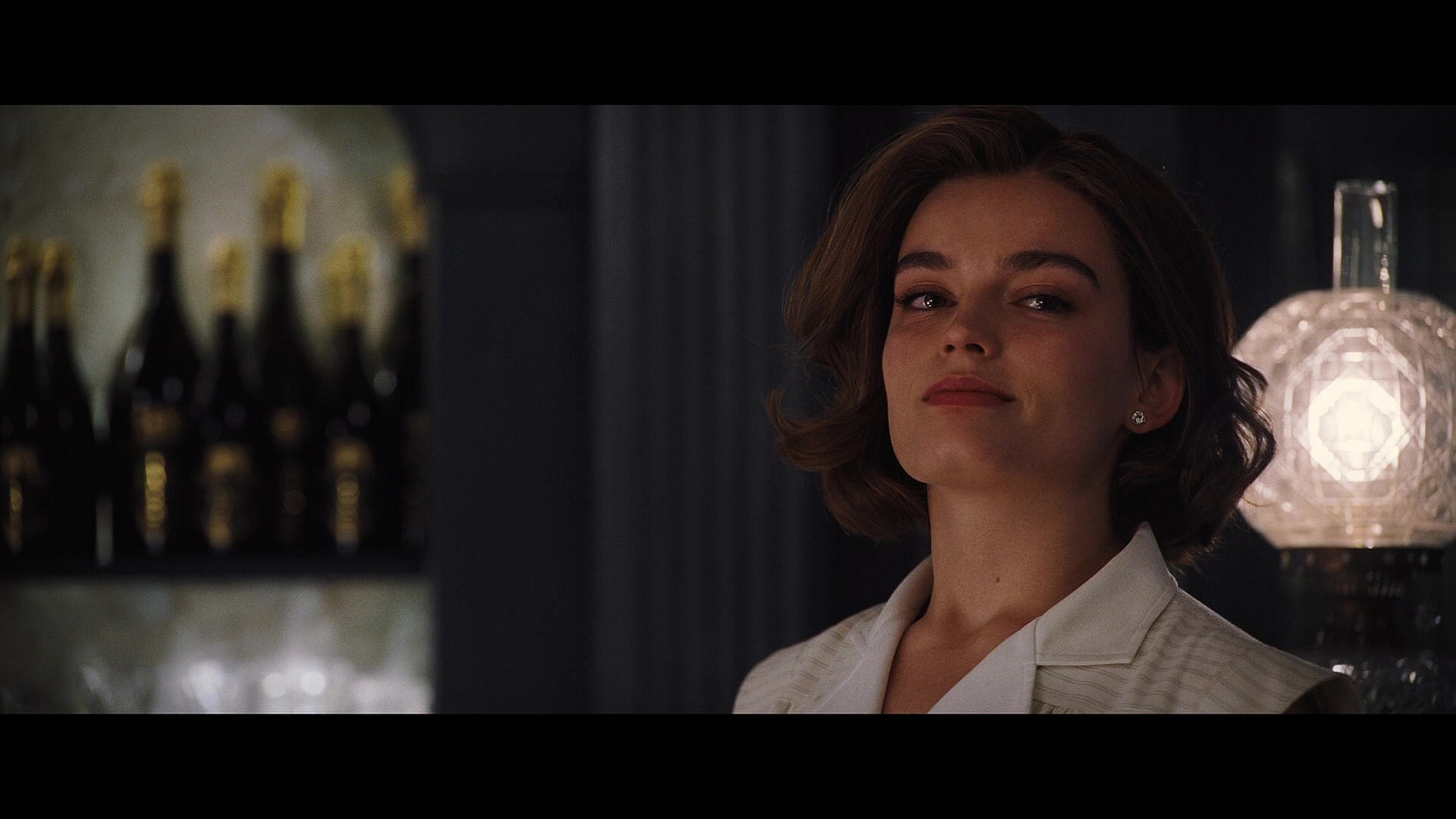 Jackie de Bellefort (Emma Mackey) listens in on Hercule Poirot's (Kenneth Branagh) theory in Death on the Nile (2022), 20th Century Studios