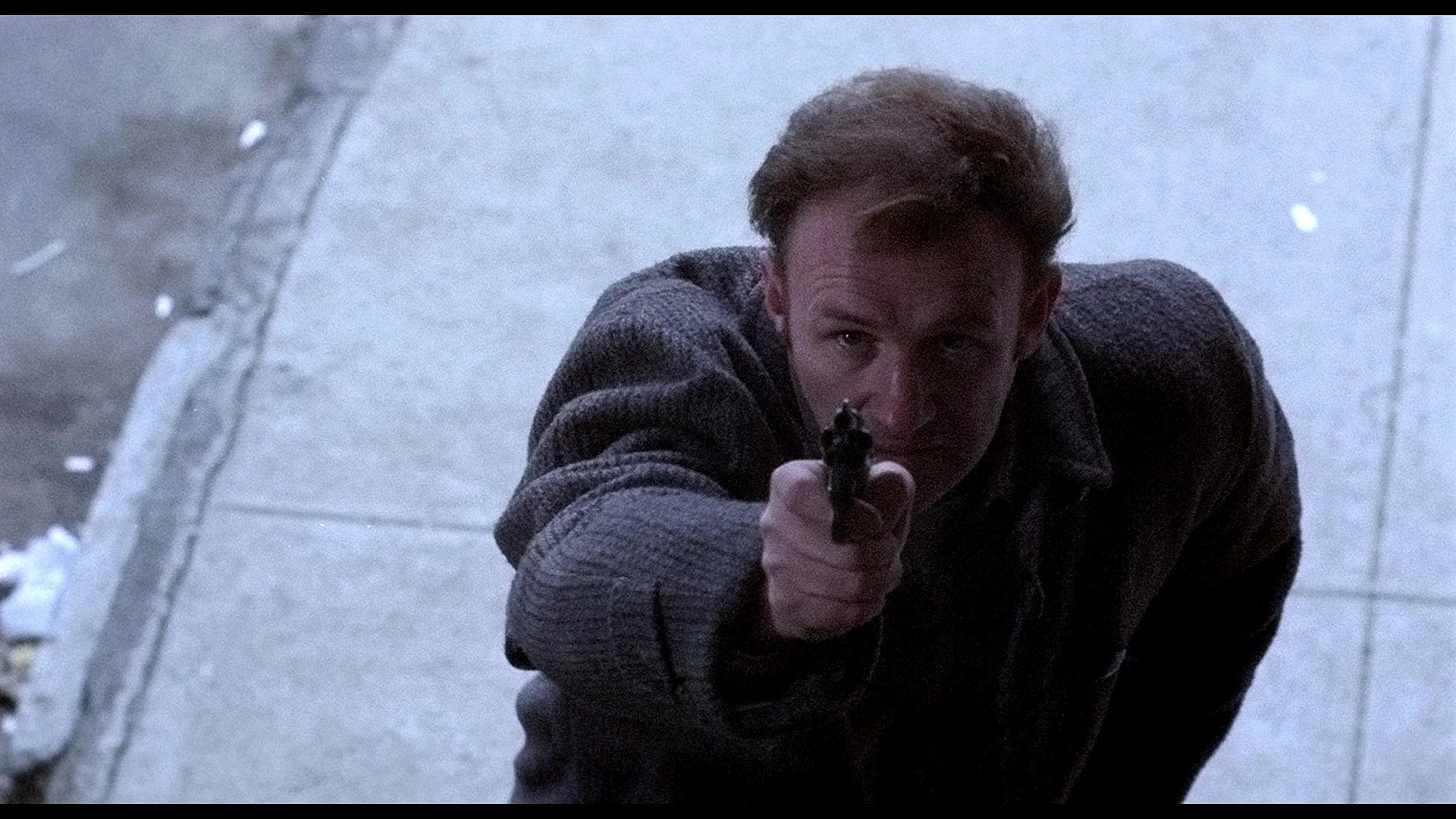 Jimmy "Popeye" Doyle (Gene Hackman) draws on Pierre Nicoli (Marcel Bozzuffi) in The French Connection (1971), 20th Century Studios