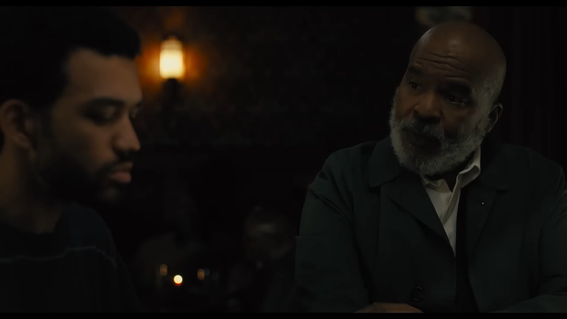 Justice Smith as Aren and David Alan Grier as Roger in The American Society of Magical Negroes (2022) , Focus Features