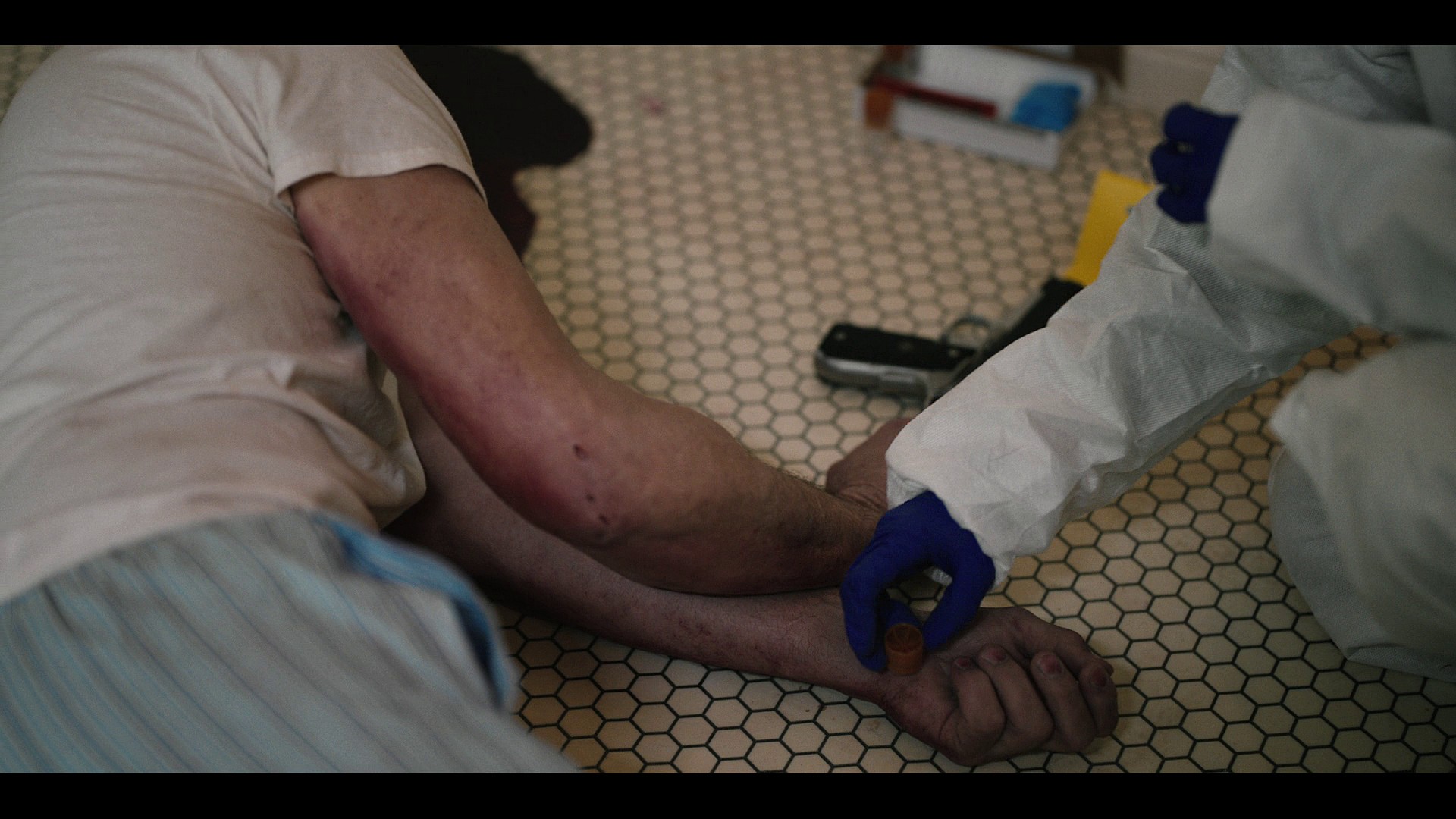 A coroner checks John Dutton's (Kevin Costner) hands for gunshot residue in Yellowstone Season 5 Episode 9 "Desire Is All You Need" (2024), Paramount Network