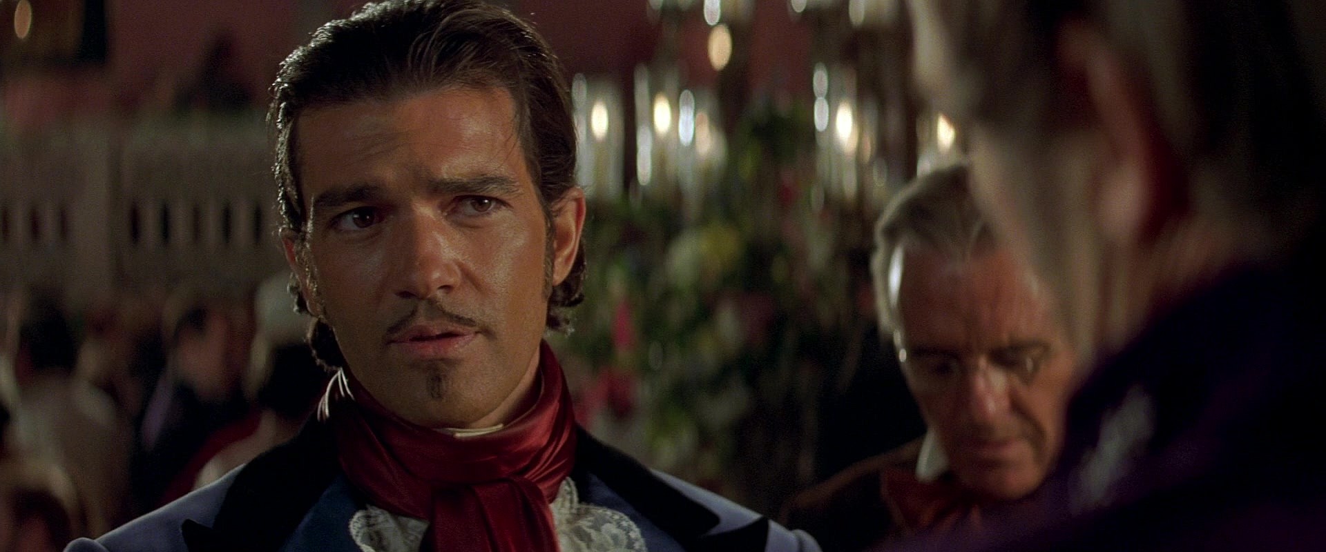Alejandro Murrieta (Antonio Banderas) poses as  Don Alejandro del Castillo y García in order to infiltrate the home of Don Rafael Montero (Stuart Wilson) in The Mask of Zorro (1998), Sony Pictures via Blu-ray