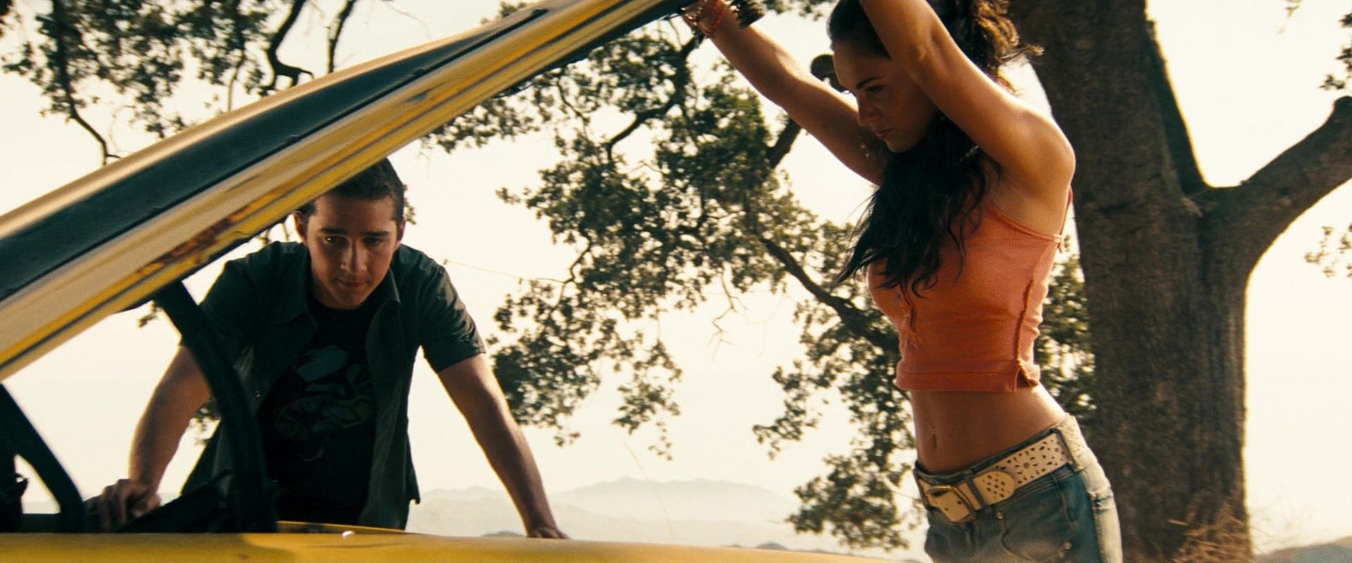 Sam Witwicky (Shia Labeouf) and Mikaela Banes (Megan Fox) pop the hood on Bumblebee in Transformers (2007) Paramount Pictures