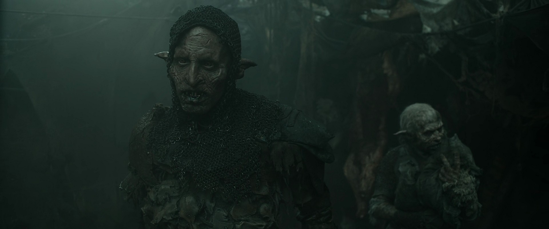 Glüg (Robert Strange) reluctantly accepts Adar's (Joseph Mawle) orders in The Lord of The Rings: The Rings of Power Season 2 Episode 3 " The Eagle and The Sceptre" (2024), Amazon Prime