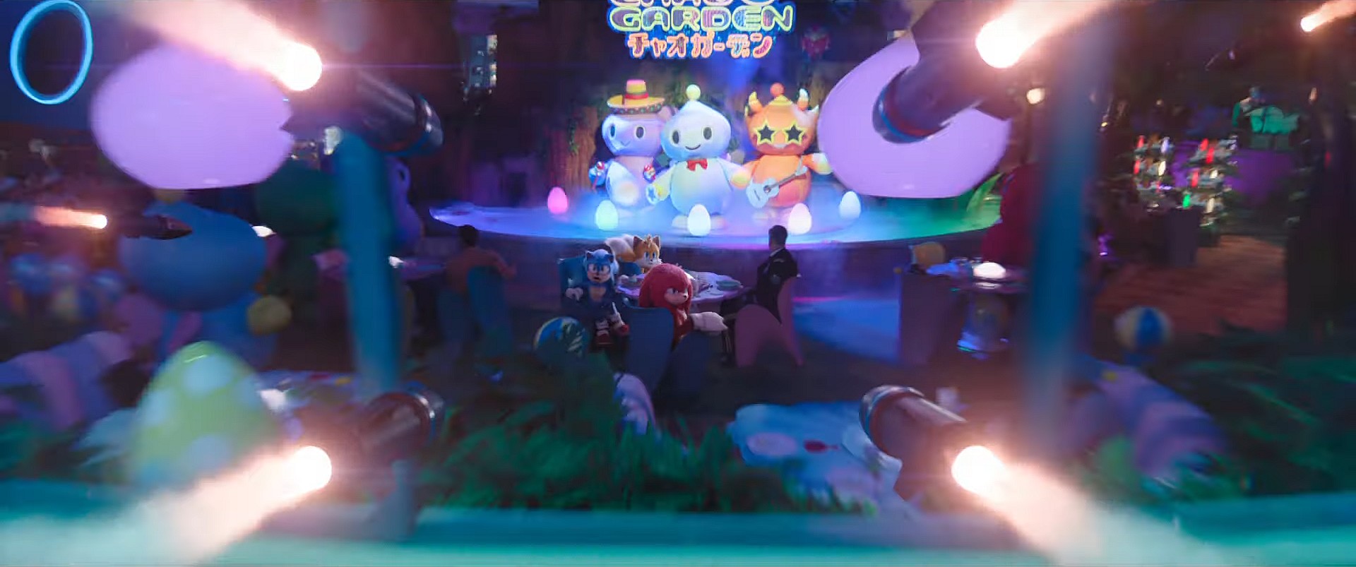 Sonic (Ben Schwartz), Tails (Colleen O'Shaughnessey), and Knuckles (Idris Elba) spy incoming missiles as they sit in the Chao Garden in Sonic the Hedgehog 3 (2024), Paramount Pictures