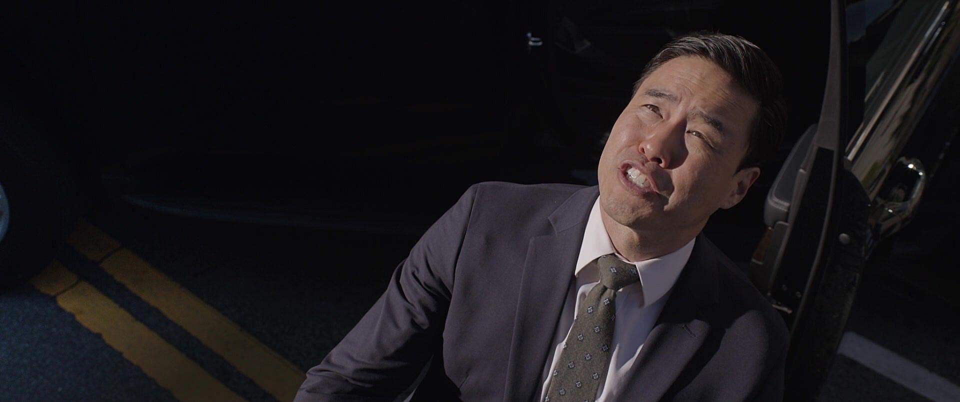 Jimmy Woo (Randall Park) attempts to arrest Scott Lang's empty Giant-Man suit in Ant-Man and the