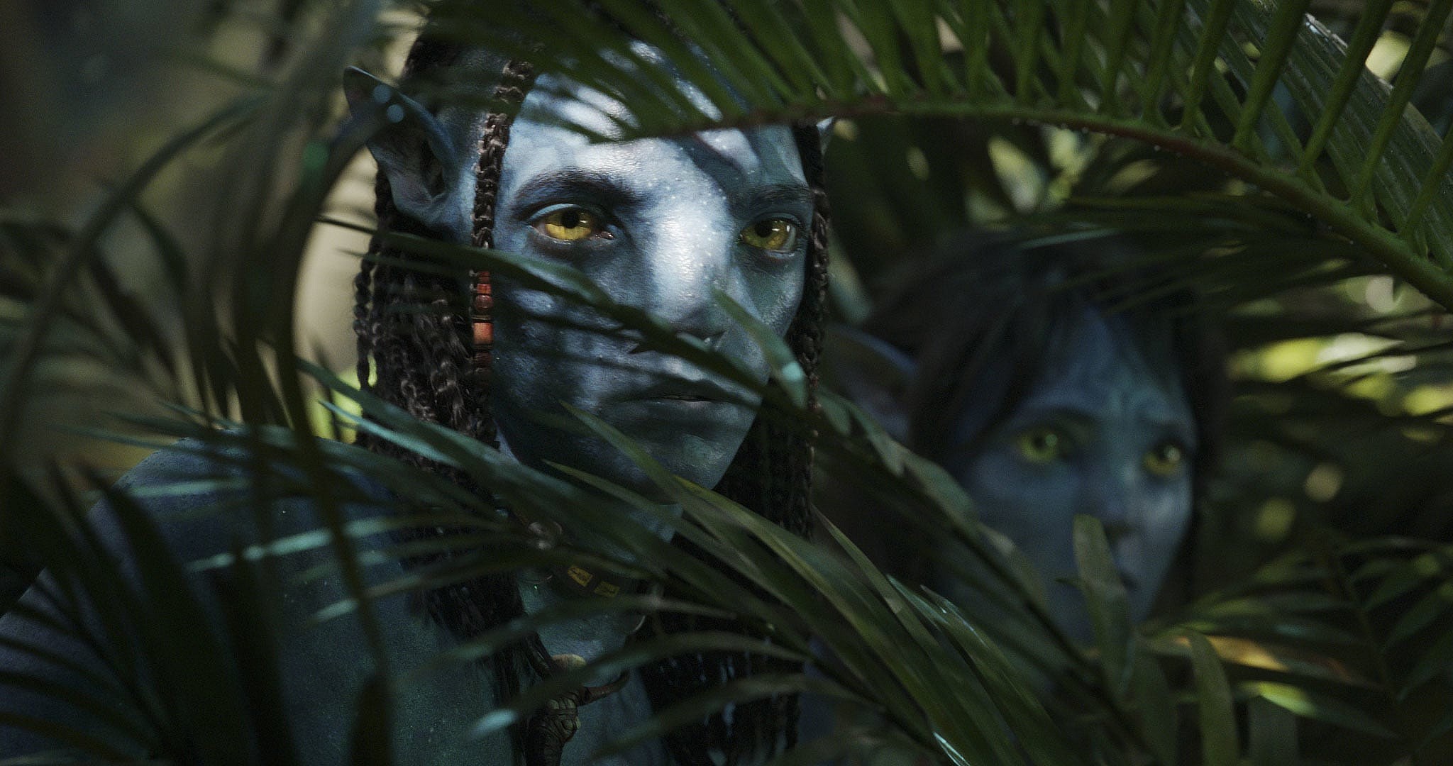 Lo'ak (Britain Dalton) and Kiri (Sigourney Weaver) peer through the brush in Avatar: The Way of Water (2022), Disney