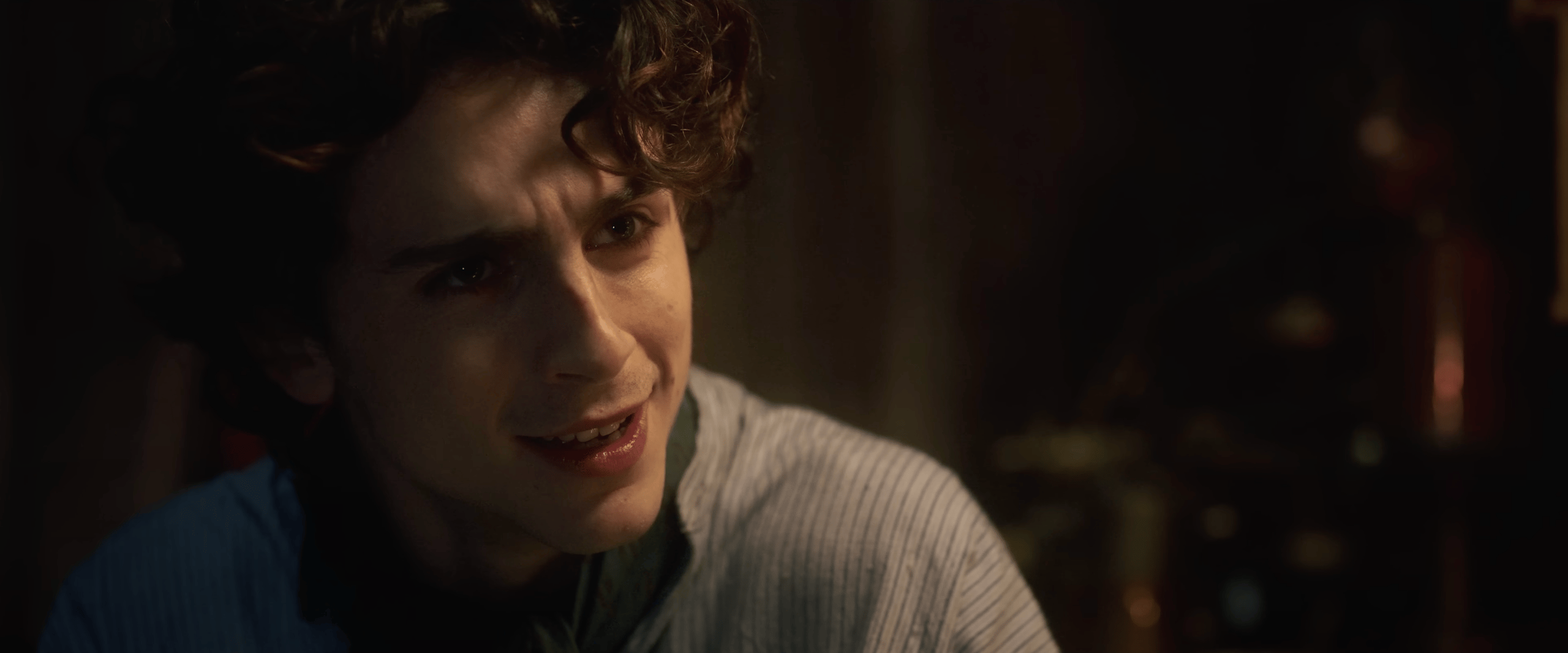 Willy Wonka (Timothée Chalamet) is first introduced to an Oompa Loompa (Hugh Grant) in Wonka (2023), Warner Bros. Pictures