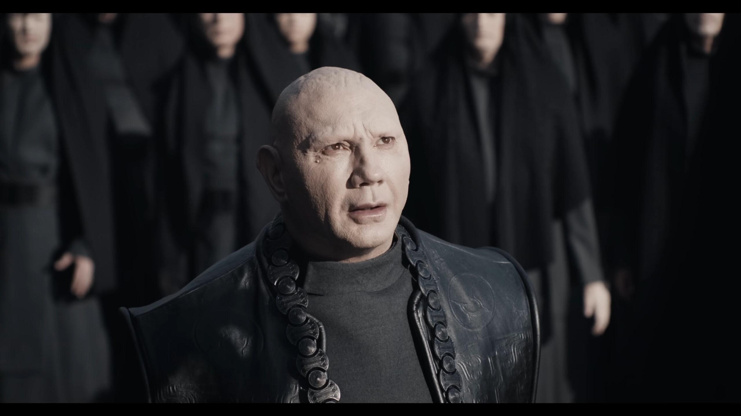 Glossu Rabban (Dave Bautista) watches on as his uncle, The Baron (Stellan Skarsgård), addresses the crowds in Dune: Part Two (2023), Warner Bros. Discovery