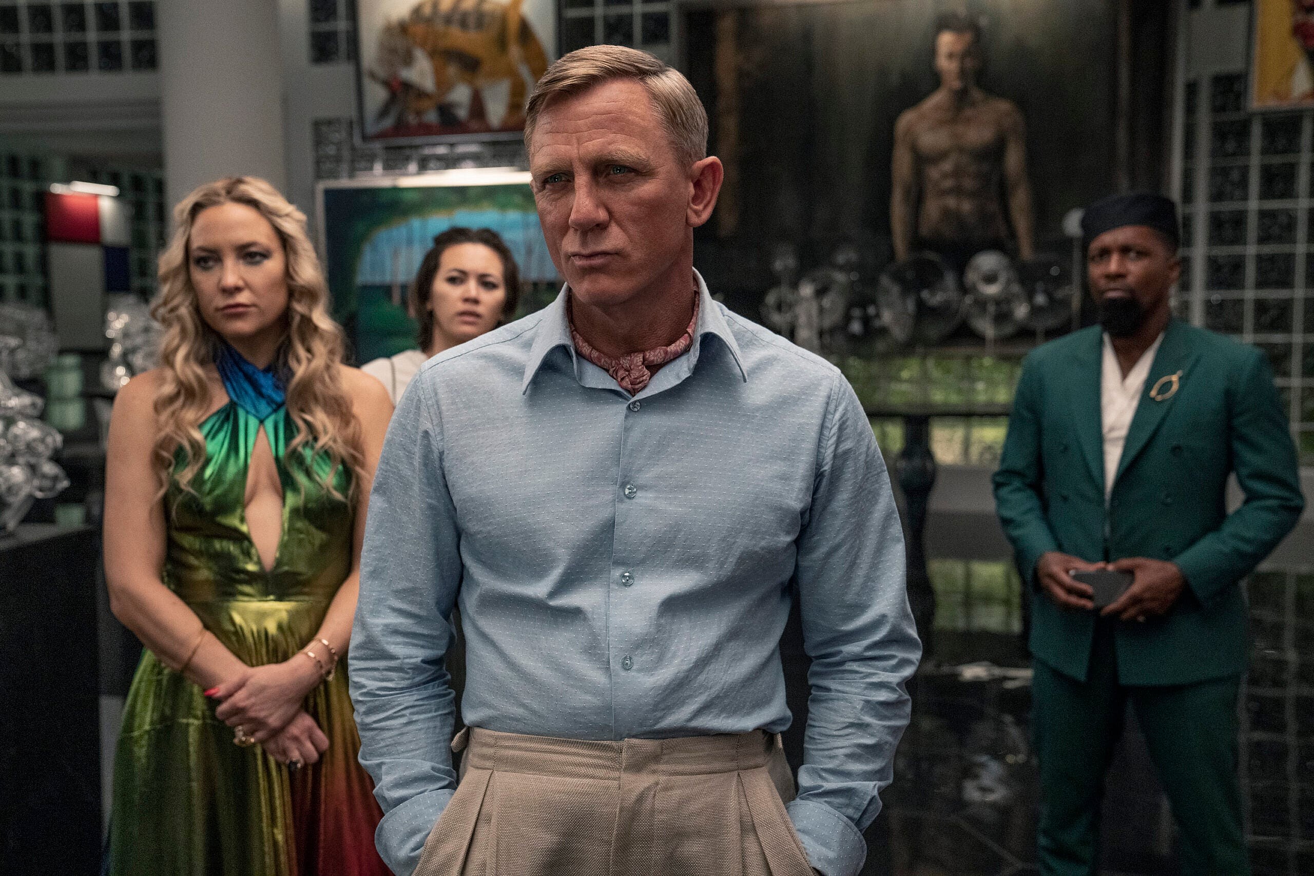 Glass Onion: A Knives Out Mystery (2022). (L - R) Kate Hudson as Birdie, Jessica Henwick as Peg, Daniel Craig as Detective Benoit Blanc, and Leslie Odom Jr. as Lionel. Cr. John Wilson/Netflix © 2022.