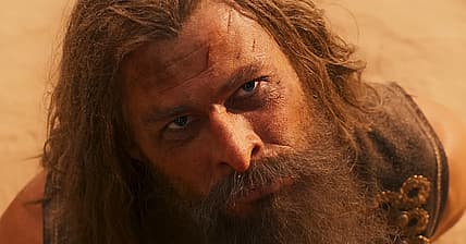 Warlord Dementus (Chris Hemsworth) at mercy of Furiosa (Anya Taylor-Joy) in Furiosa: A Mad Max Saga