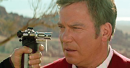 Captain Kirk (William Shatner) finds himself held at Phaser-point by Tolian Soran (Malcolm McDowell) in Star Trek Generations (1994), Paramount Pictures