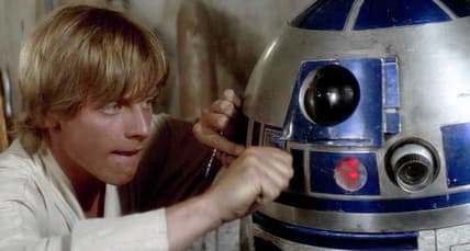 Luke Skywalker (Mark Hamill) attempts to fix his newly-purchased R2 unit (Kenny Baker) in Star Wars - Episode IV: A New Hope (1977), Lucasfilm