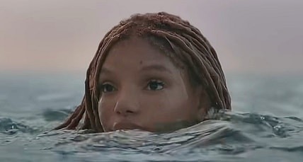 Ariel (Halle Bailey) pops her head above the ocean's surface in The Little Mermaid (2023), Disney