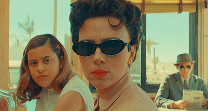 (L to R) Grace Edwards as "Dinah", Scarlett Johansson as "Midge Campbell" and Damien Bonnaro as "Bodyguard/Driver" in writer/director Wes Anderson's ASTEROID CITY, a Focus Features release. Credit: Courtesy of Pop. 87 Productions/Focus Features