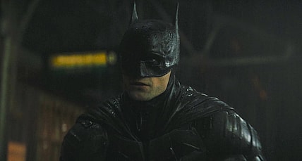 Batman (Robert Pattinson) reveals himself to a gang attempting a robbery in The Batman (2022), Warner Bros. Pictures