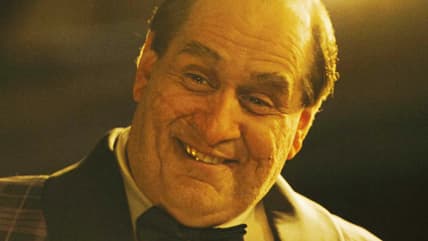 Oswald Cobblepot (Colin Farrell) tries to schmooze Batman (Robert Pattinson) after he barges into The Iceburg Lounge in The Batman (2022), Warner Bros. Pictures