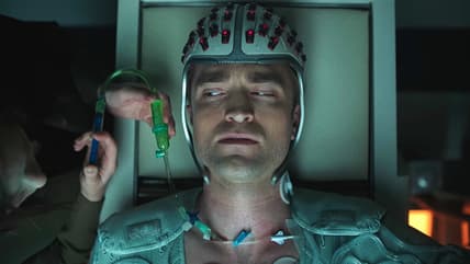 Mickey (Robert Pattinson) wears his special helmet for his shots in Mickey 17 (2025), Warner Bros. Pictures