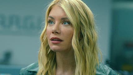 Harcourt (Jennifer Holland) questions Chris (John Cena) about being on Earth-X in Peacemaker Season