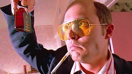 Raoul Duke (Johnny Depp) retrieves a vial of adrenochrome from Dr. Gonzo's (Benicio Del Toro) bag in Fear and Loathing in Las Vegas (1998), Universal Pictures