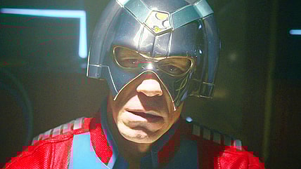 Peacemaker (John Cena) can hear the Justice Gang mocking him thanks to some faulty A/V wiring in Peacemaker Season 2 Episode 1 "The Ties That Grind" (2025), DC Studios