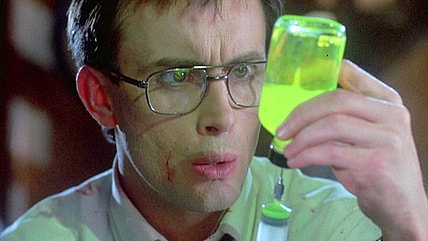 Herbert (Jeffrey Combs) experiments with his new discovery in Re-Animator (1985), Empire International Pictures