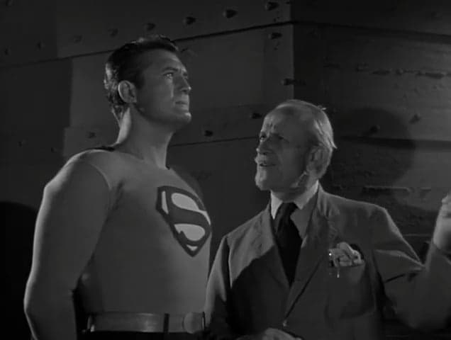 Professor Roberts (Jonathan Hale) alerts Superman (George Reeves) to an impending meteor strike in Adventures of Superman Season 2 Episode 12 "Panic in the Sky" (1952), National Comics Publication