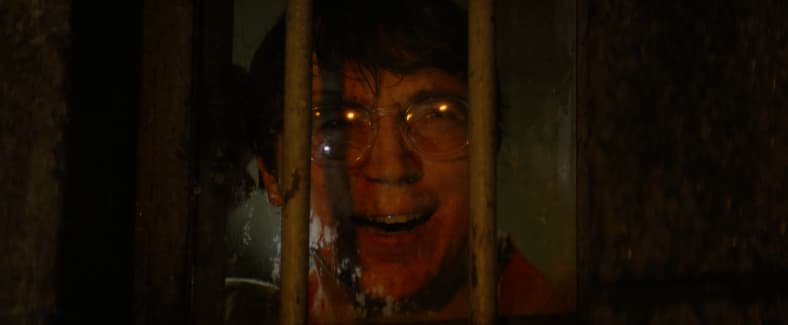 The Riddler (Paul Dano) watches as his plan unfolds in The Batman (2022) via Warner Bros. Pictures