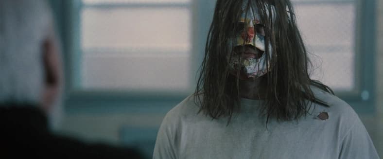 A fully grown Myers (Tyler Mane) sits and listens to Dr. Loomis (Malcolm McDowell) in Halloween (2007), Dimension Films