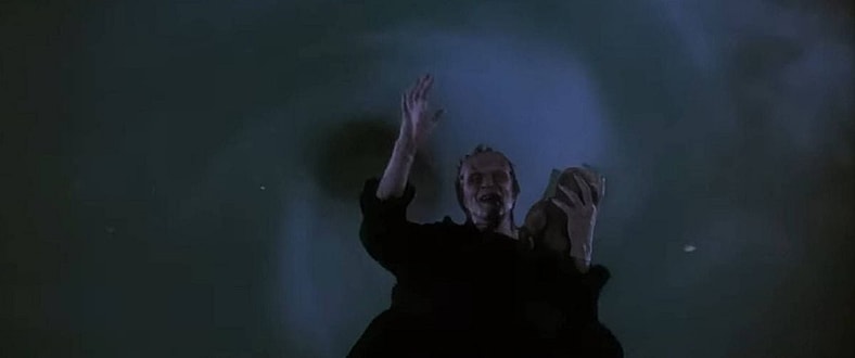 Frankenstein's Monster (Tom Noonan) waves goodbye before being sucked into limbo in The Monster Squad (1987), TriStar Pictures