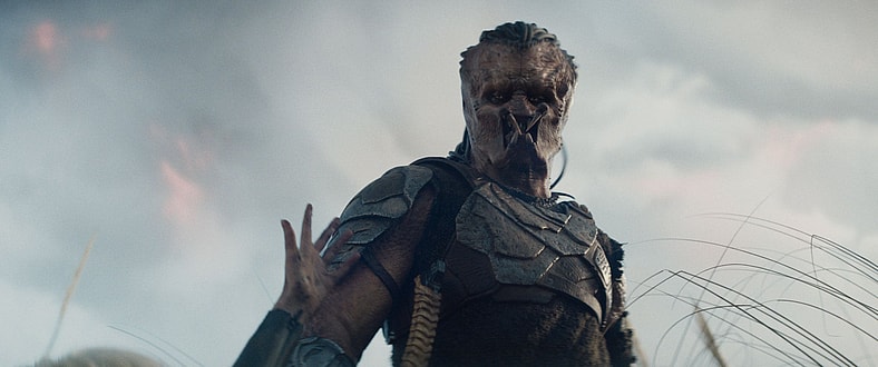 Thia (Elle Fanning) offers Dek (Dimitrius Schuster-Koloamatangi) a helping hand in Predator: Badlands (2025), 20th Century Studios