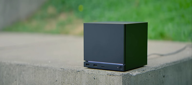 A Steam Machine outside on a concrete slab near grass in a bowl in Steam Hardware Announcement Trailer, via YouTube