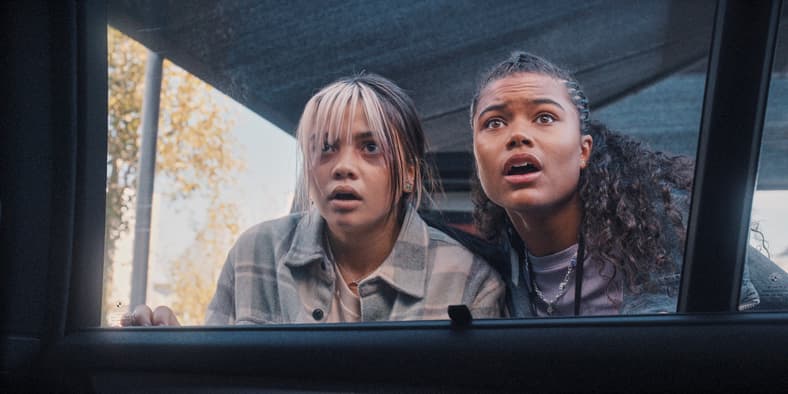 Billie (Siena Agudong) and Jade Wesker (Tamara Smart) attempt to sneak past an Umbrella security unit in Resident Evil Season 1 Episode 2 "The Devil You Know" (2022), Netflix