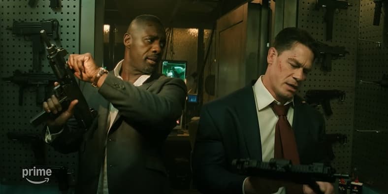 Sam Clarke (Idris Elba) and Will Derringer (John Cena) brandishing new weapons at Marty Cormer's (Jack Quaid) armory in Heads of State (2025), Metro-Goldwyn-Mayer