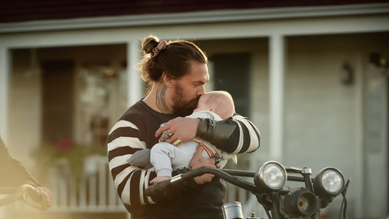 Arthur Curry (Jason Momoa) holds his newborn son in Aquaman and the Lost Kingdom (2023), Warner