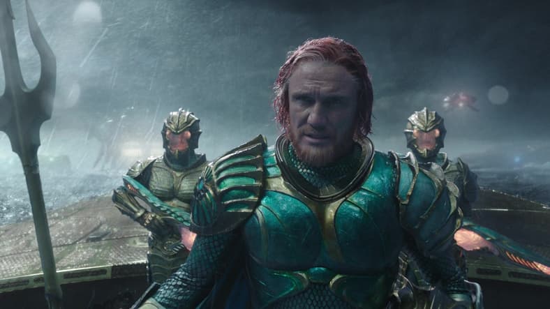 King Nereus (Dolph Lundgren) patiently watches as the battle between Aquaman (Jason Momoa) and Ocean Master (Patrick Wilson) unfolds in Aquaman (2018), Warner Bros. Pictures