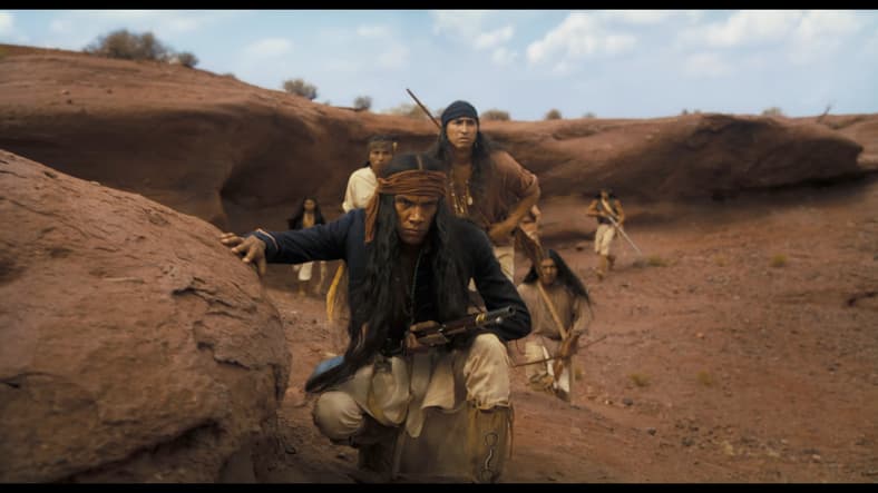 A Native American resistance fighter (Tatanka Means) prepares to ambush a group of settlers in Horizon: An American Saga (2024), New Line Cinema