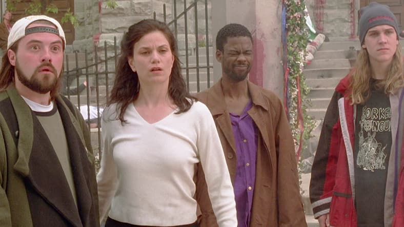 Silent Bob (Kevin Smith), Bethany (Linda Fiorentino), Rufus (Chris Rock), and Jay (Jason Mewes) watch on in shock as Bartleby (Ben Affleck) stabs Loki (Matt Damon) in Dogma (1999), View Askew Productions